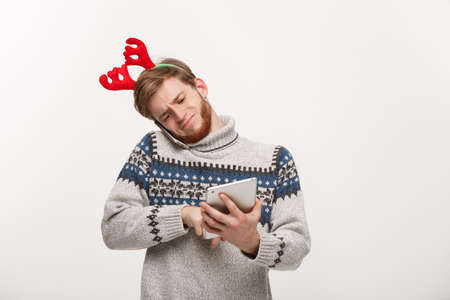 Holiday and Business Concept - Young handsome man busy working on phone and digital tablet.の写真素材