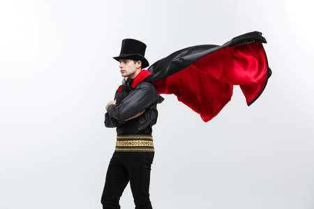 Vampire Halloween Concept - Portrait of handsome caucasian Vampire halloween costume fluttering his red, black cloak.の写真素材