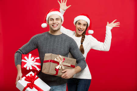 Christmas Concept - Young attractive couple holding a lot of presents enjoy shopping and celebrating in Christmas dayの写真素材