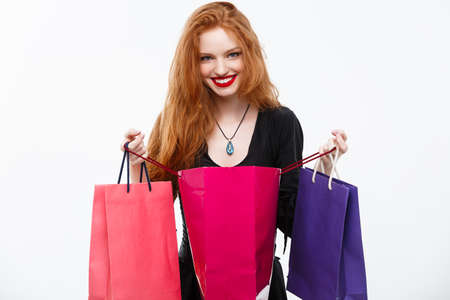Halloween witch concept - Happy Halloween Witch smiling and holding colorful shopping bags on white background.の写真素材
