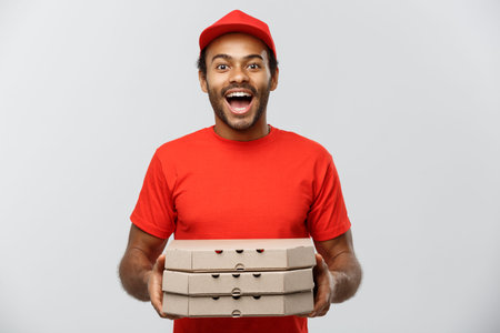 Delivery Concept - Portrait of Handsome African American Pizza delivery man. Isolated on Grey studio Background. Copy Space.の写真素材