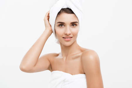 Beauty and Skin care concept - Beautiful caucasian Young Woman with bath towel on head covering her breasts, on white.の写真素材