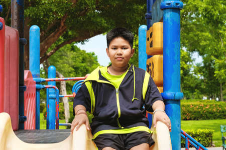 Sport and lifestyle Concept: Young asian boy sitting on playground at outdoor playground.の写真素材