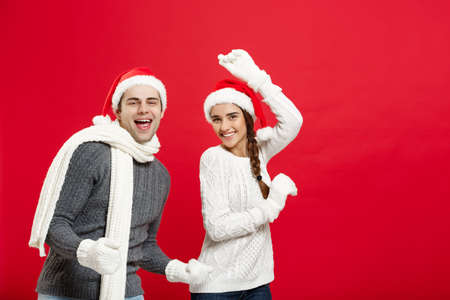 Christmas concept - Happy young couple in sweatesr celebrating christmas with playing and dancingの写真素材