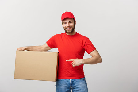Delivery Concept - Portrait of Happy Caucasian delivery man pointing hand to present a box package....