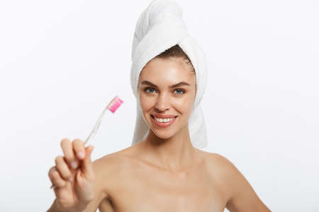 Smiling woman brushing her teeth with towel on her head. A great smileの写真素材