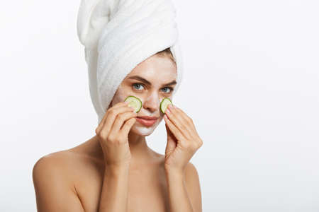 Beauty Portrait Of Smiling Woman With Towel On Head And Slice Of Cucumber In Hand Isolated On White Background.の写真素材