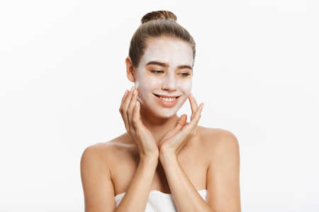Beautiful woman with facial white mask on white backgroundの写真素材