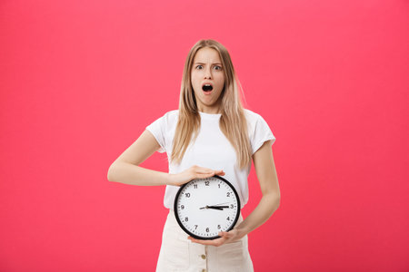 Amazed woman holding clock. Surprised woman in white t-shirt holds black clock. Retro style. Saving...
