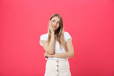 Bored woman. Boring, dull, tedious concept. Young pretty caucasian emotional woman. Human emotions, facial expression concept. Studio Isolated on trendy pink backgroundの写真素材