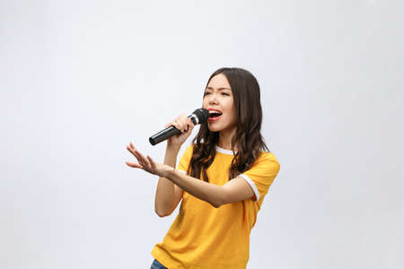 beautiful stylish woman singing karaoke isolated over white background.の写真素材