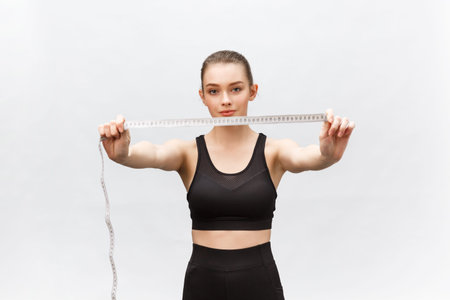 Portrait of attractive caucasian smiling woman with measuring tape isolated on white background.