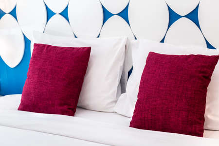 Luxury bed and pillow with light and wooden headboard.の写真素材