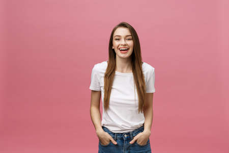 Surprised happy beautiful woman looking in excitement. Isolate over pink background and copy space.の写真素材