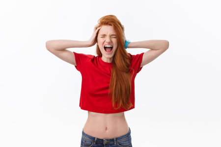 Picture of angry young woman standing isolated over white background. Looking camera