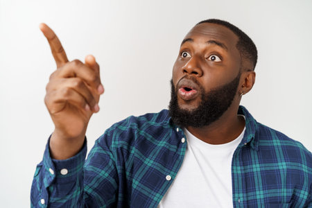 Young african man over white background pointing upwards