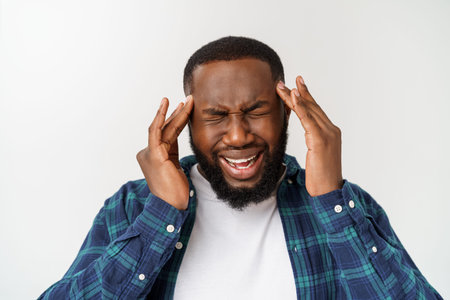 Studio shot of young handsome African man against white background.
