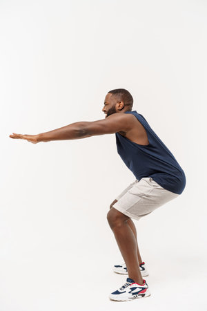 African sport man exercising and stretching on white backgroundの写真素材
