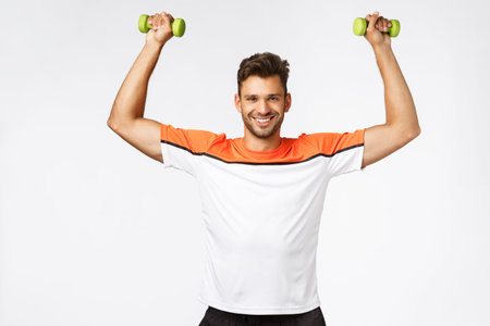 Sport and gym membership promo. Satisfied handsome muscular guy with bristle in sportswear lift...