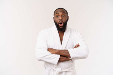 Black guy wearing a bathrobe pointing finger with surprise and happy emotion. Isolated over whtie background.の写真素材