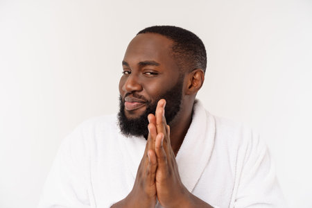 Black guy wearing a bathrobe pointing finger with surprise and happy emotion. Isolated over whtie...