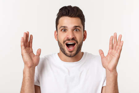 Portrait of young man with shocked facial expression, isolated over white background.の写真素材