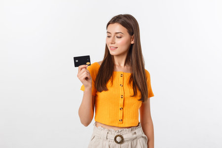 beautiful friendly smiling confident girl showing black card in hand, isolated over white...