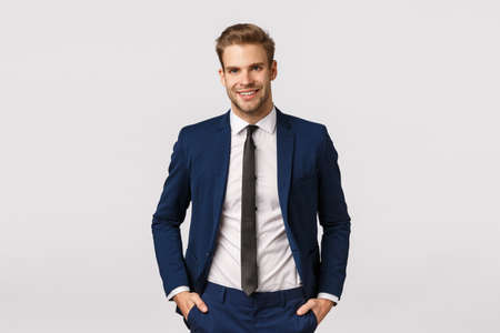 Handsome confident blond bearded businessman, holding hands in pockets, smiling joyfully, give professional vibe, discussing business, double his income, become successful, white backgroundの写真素材