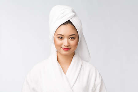 Portrait of a young happy asian lady in bathrobe.Isolated in white background.の写真素材