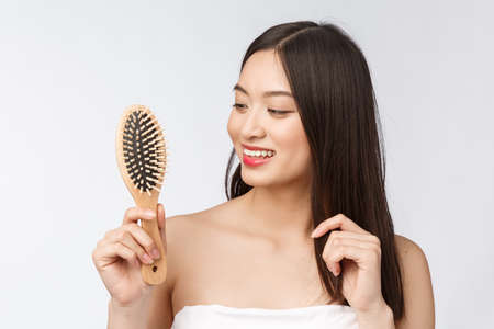 portrait of a beautiful young woman comb wonderful hair isolated on white background, asian beautyの写真素材