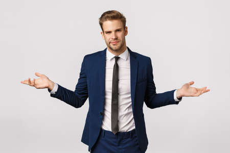 I dont know. Unsure and puzzled handsome businessman with bristle, blond haircut, wear suit, spread hands sideways and shrugging uncertain, have doubts about client, frowning perplexedの写真素材