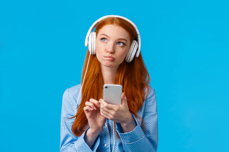 Thoughtful and creative, pensive caucasian redhead woman, foxy girl in nightwear, looking up...
