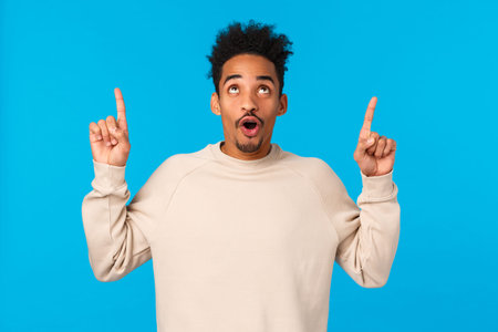 Wow awesome. Impressed good-looking african guy with moustache and afro haircut, folding lips...
