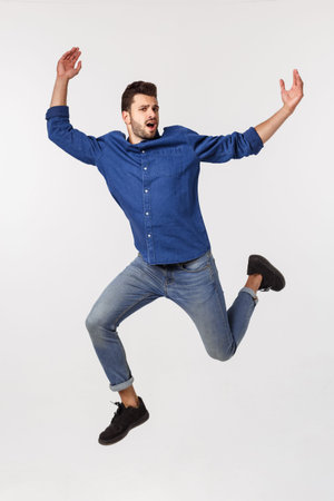 An attractive athletic businessman jumping up against white background