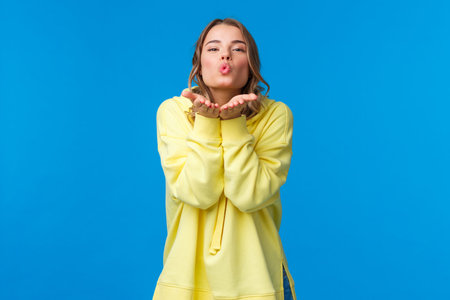 Send you passionate kisses through camera. Tender and silly girlfriend with blond short hair holding...