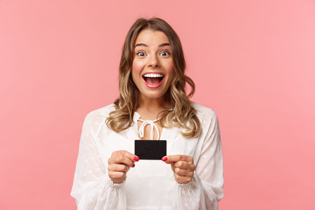 Close-up portrait of excited and happy good-looking blond female recommend bank, smiling amazed,...