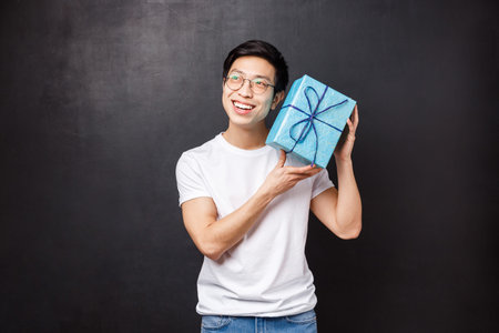 Celebration, holidays and lifestyle concept. Excited and curious happy young asian man celebrating...