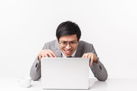 Portrait of distressed, pressured and stressed young asian office worker work hard over project,...