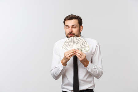 Closeup of cheerful young businessman holding money over white background.の写真素材