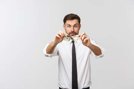 Portrait of confident smart handsome salesman holding two halves on banknote isolated on gray backgroundの写真素材