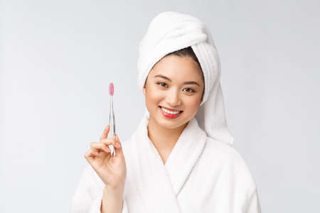 Asian happy woman with toothbrush in bathrobe morning moodの写真素材