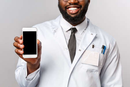 Healthcare, medicine and hospital treatment concept. Cropped shot of smiling doctor, african american therapist recommend staying in touch with physician using mobile application, online appointmentの写真素材