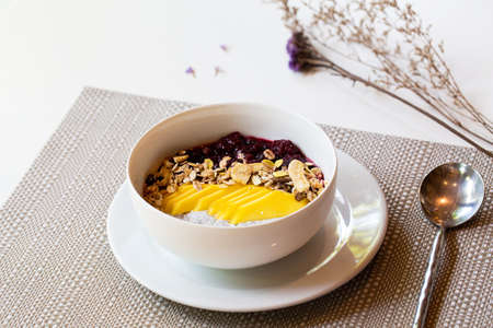 Breakfast berry smoothie bowl topped with blueberry,almond, banana and chia seedsの写真素材