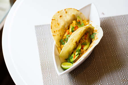 Mexican breakfast of a breakfast taco. Sides of pico de gallo, avocado, lime and jalapeno.の写真素材