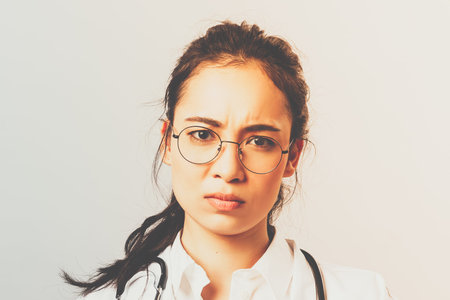 Healthcare, medicine and pharmacy concept. Portrait of worried asian female doctor, frowning disturbed, thumbs-down and hold bad pills, advice not to self-medicate from virus, contact your therapistの写真素材