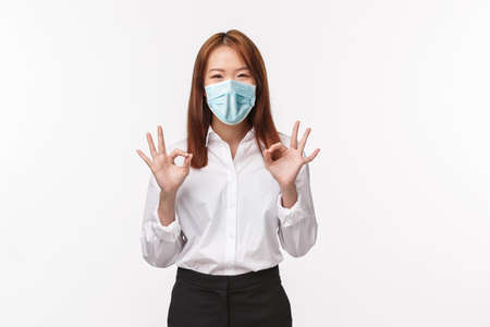 Relax, everything okay. Cheerful and carefree asian woman say no problem, make ok gesture and smiling, assure everything done, deal signed, guarantee great service and quality, white backgroundの写真素材