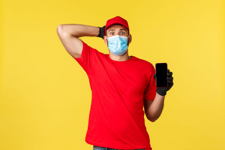 Food delivery, tracking orders, covid-19 and self-quarantine concept. Worried and confused young...
