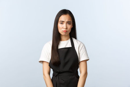 Coffee shop, small business and startup concept. Gloomy and sad cute asian barista, female cafe...
