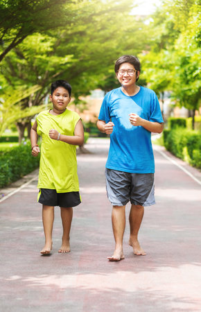 Asian couple of brother run together in park.