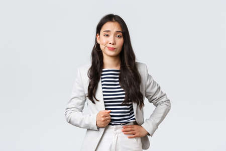 Business, finance and employment, female successful entrepreneurs concept. Arrogant and confident young asian businesswoman looking unimpressed, make skeptical smirkの写真素材